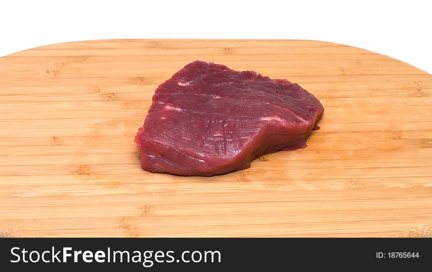 Piece of beef on a wooden cutting board. Piece of beef on a wooden cutting board.