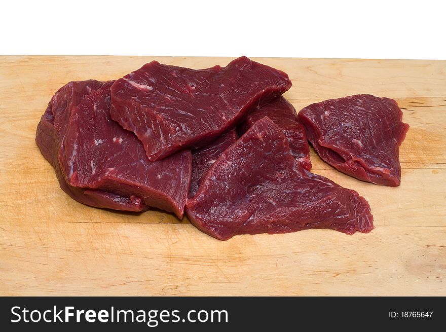 Piece of beef on a wooden cutting board. Piece of beef on a wooden cutting board.