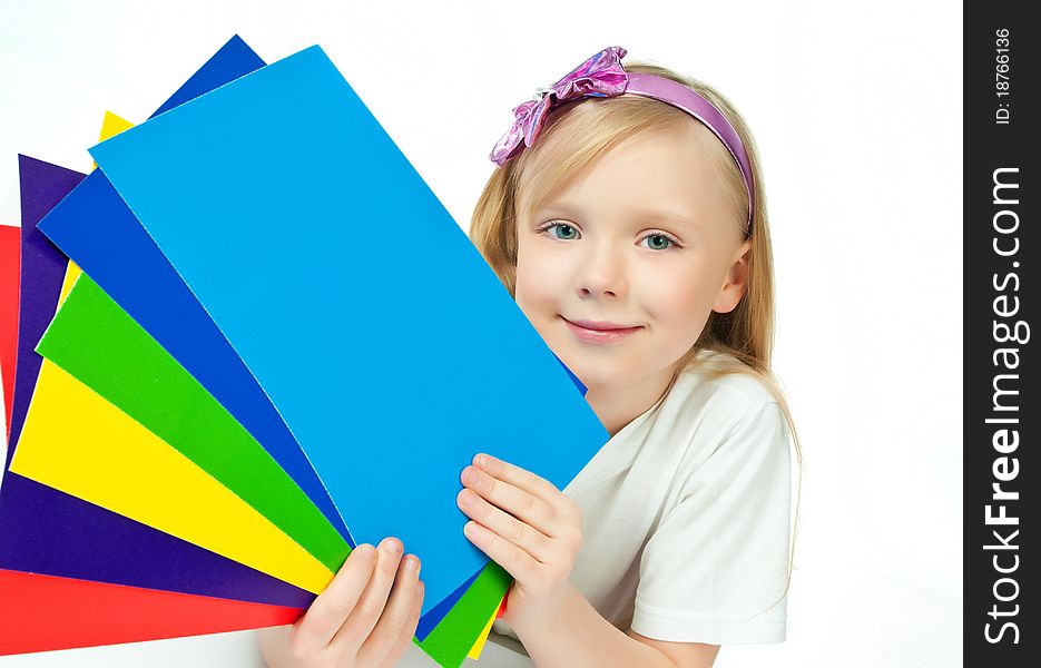 Cute little girl with the colored paper