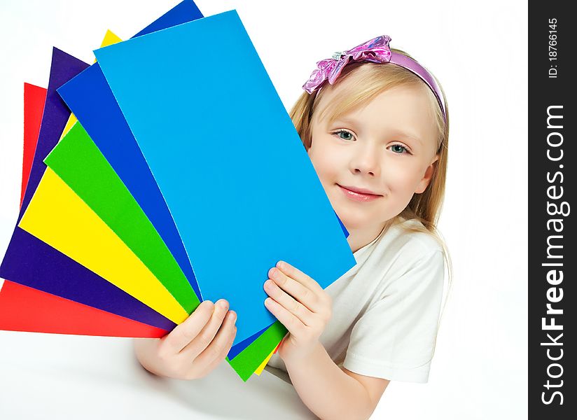 Cute little girl with the colored paper