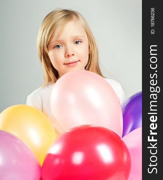 Cute little girl with balloons on white