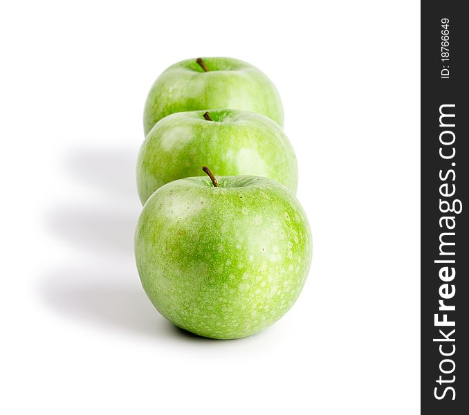 Three ripe and juicy green apples located in a line one after another isolated on a white background. Three ripe and juicy green apples located in a line one after another isolated on a white background