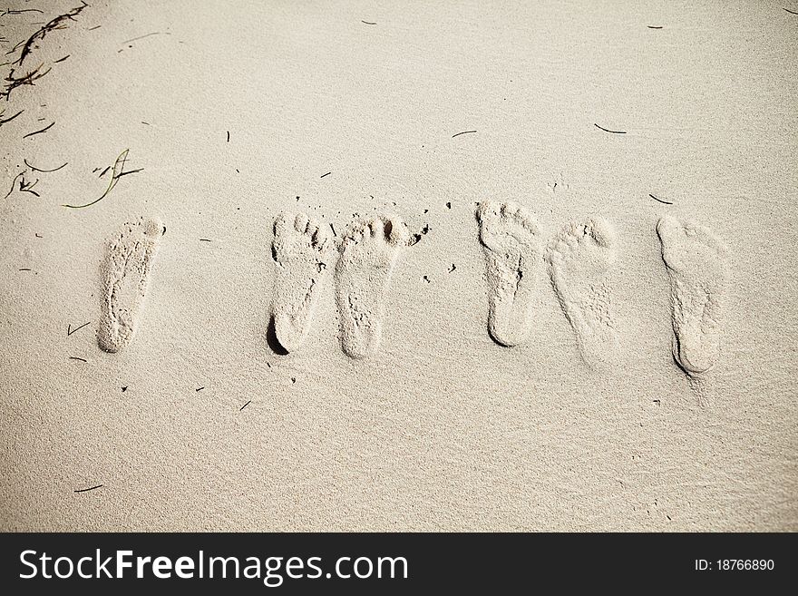 Six footsteps on the sand on the beach