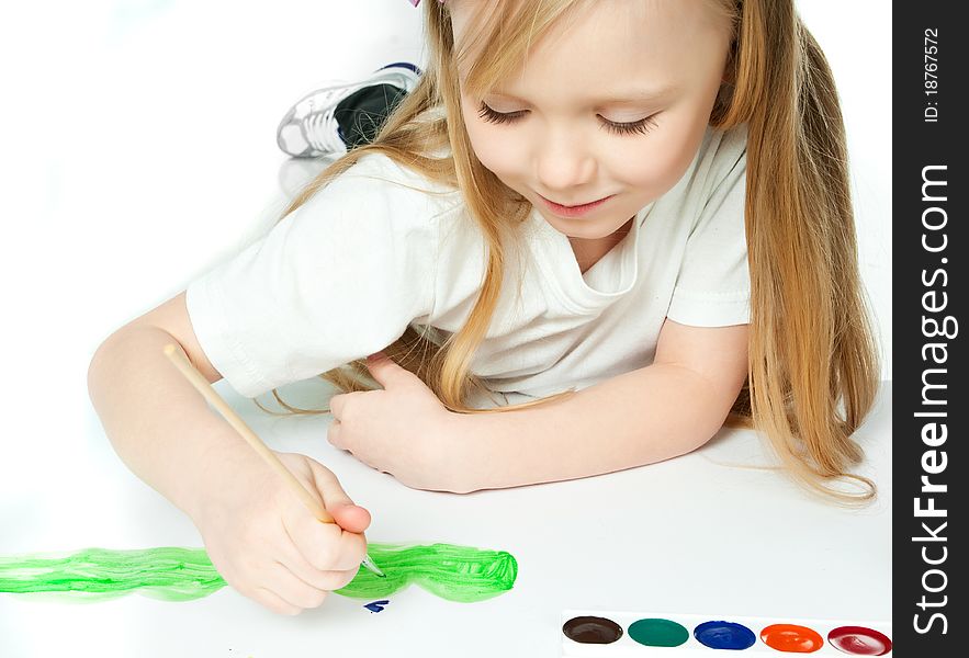 Cute little girl with a brush and paints