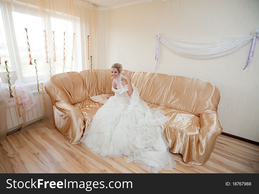 Happy bride waiting for a groom on the sofa. Happy bride waiting for a groom on the sofa