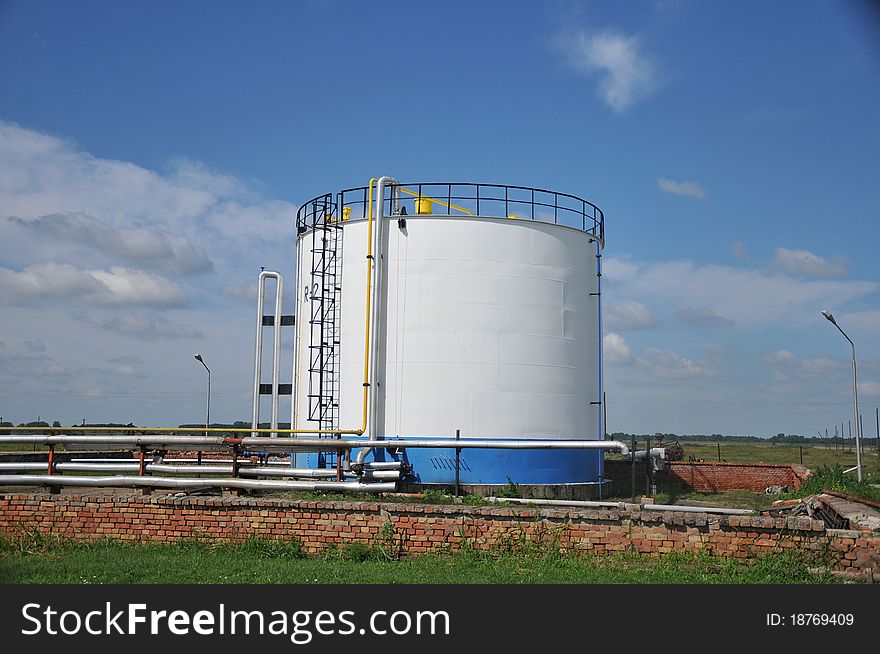 Oil tank with stairs against blue sky