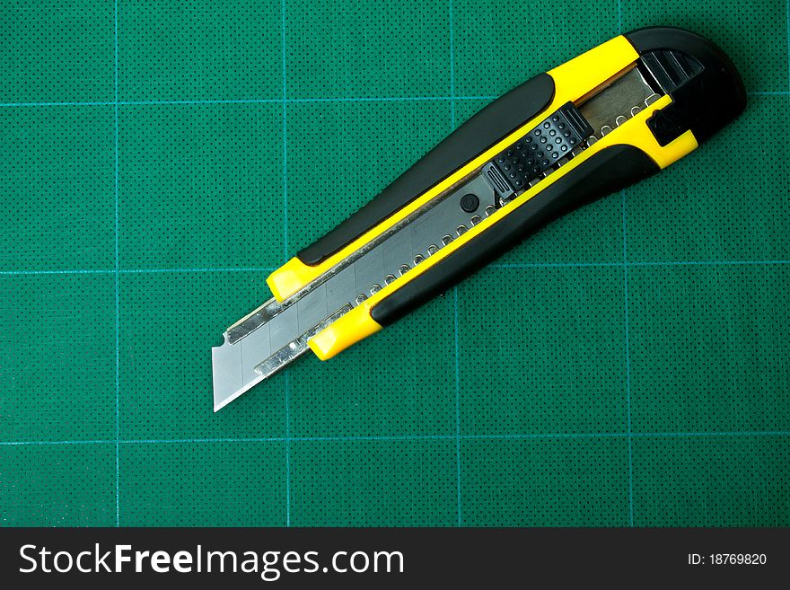 Box cutter placed on green cutting mat. Box cutter placed on green cutting mat.