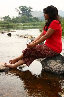 Indian Woman In Red Dress Sitting On A Rock Stock Images