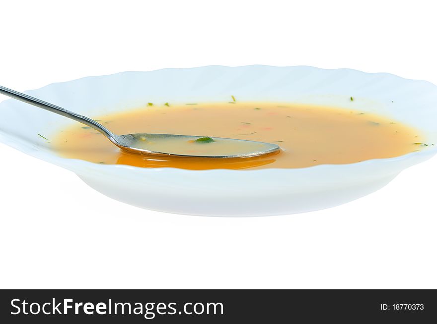 Spoon in a soup plate on white background