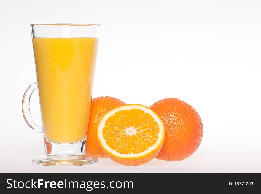 A cup of fresh made, home made, healthy, tasty orange juice in glass cup with an oranges next to it. A cup of fresh made, home made, healthy, tasty orange juice in glass cup with an oranges next to it