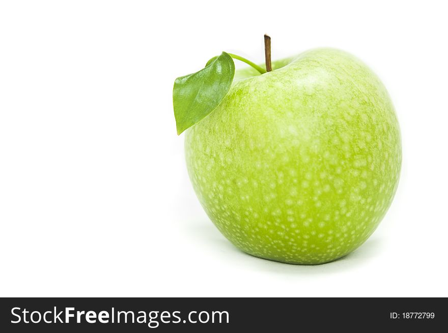 Green apple in a speck on a white background with green sheet and a branch part