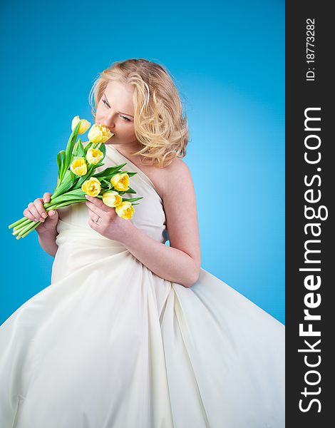 Young beautiful woman with flowing hair holding a bouquet of tulips