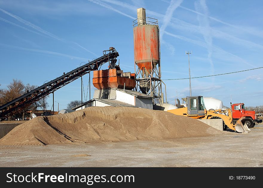 Small town cement plant on clear day with blue sky. Small town cement plant on clear day with blue sky