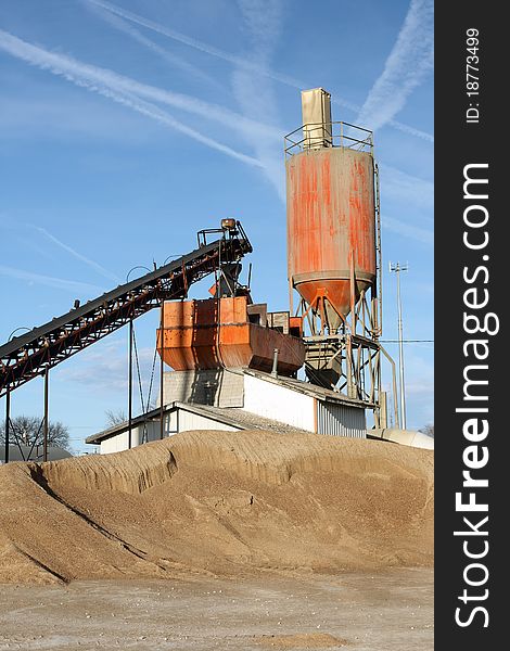 Vertical view of small town cement plant on clear blue day. Vertical view of small town cement plant on clear blue day