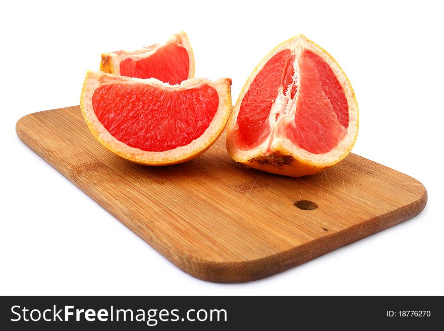 Grapefruit slices on a cutting board over white background