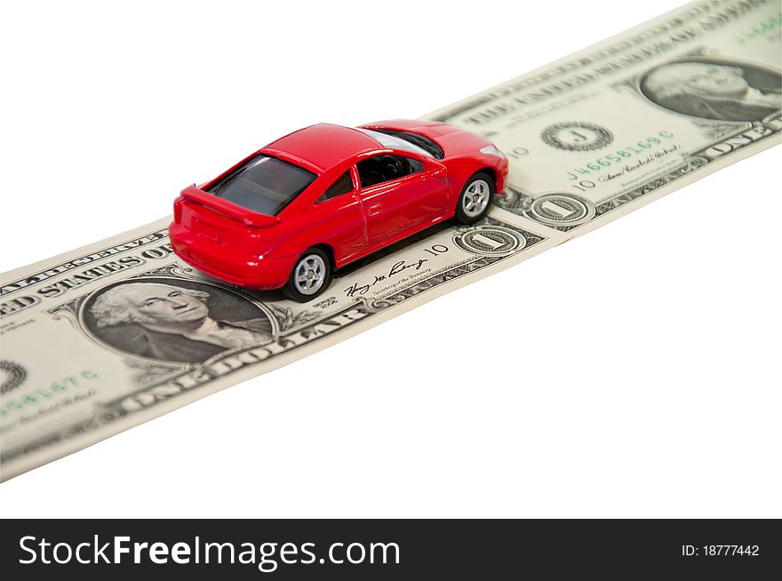 Red car on dollar denominations isolated on white background