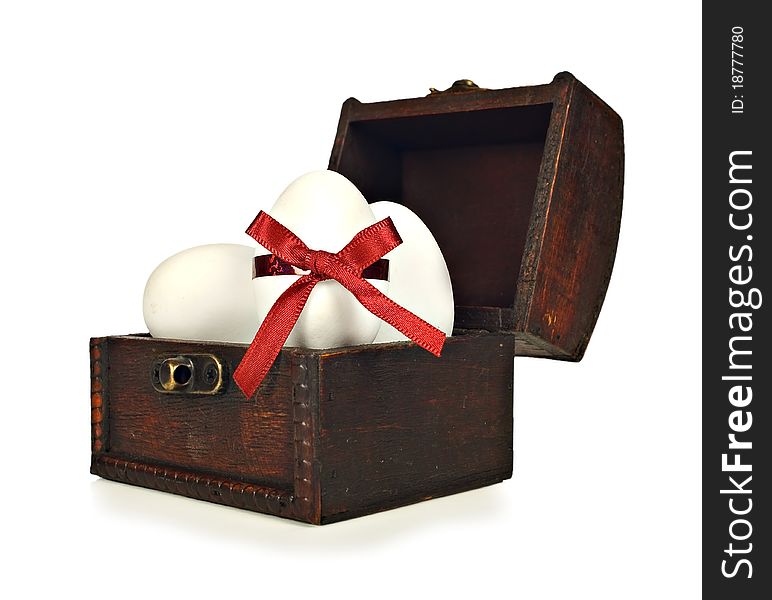 White candy easter eggs in a chest on a white background