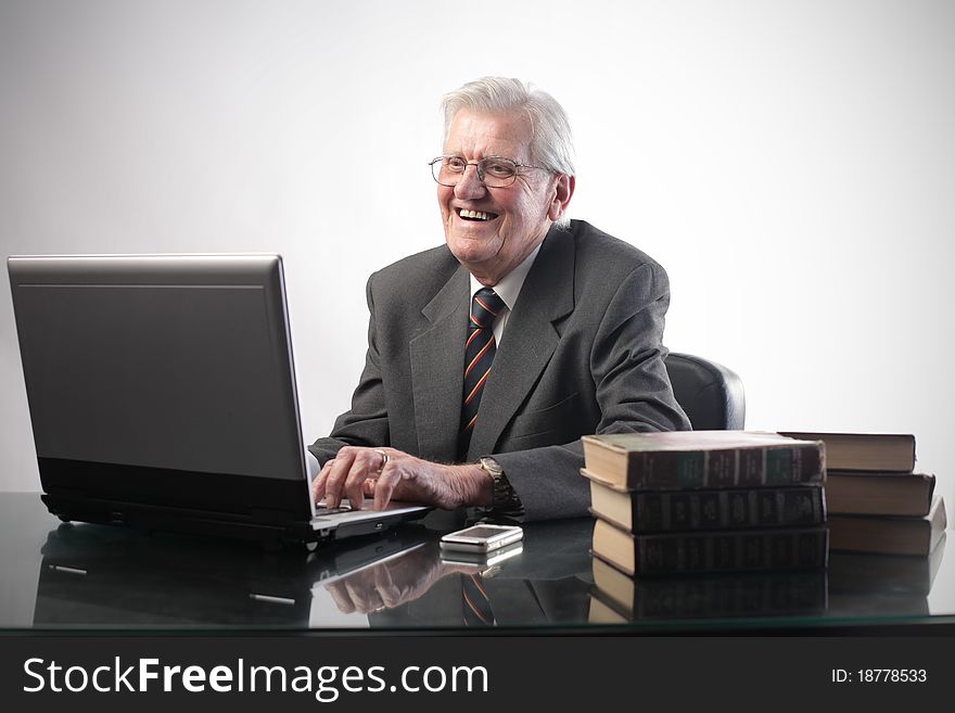 Smiling senior businessman using a laptop. Smiling senior businessman using a laptop