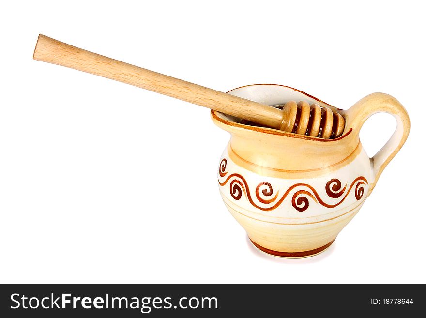 Honey in a jug and wooden stick