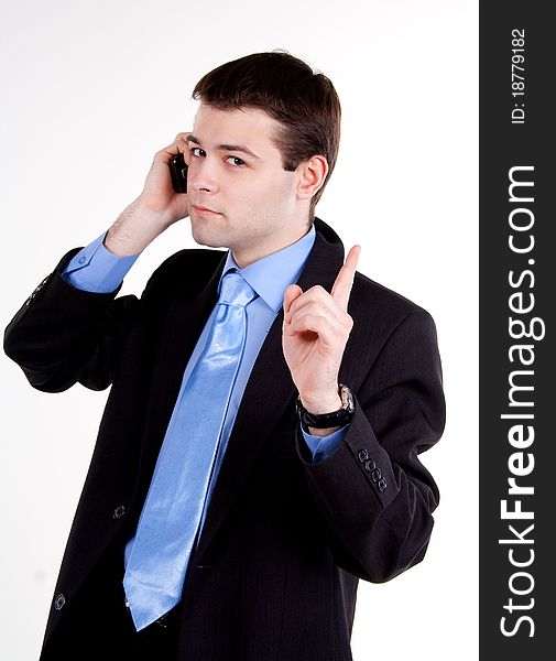 Portrait of young business man talking on cellphone and gesturing silence. Portrait of young business man talking on cellphone and gesturing silence