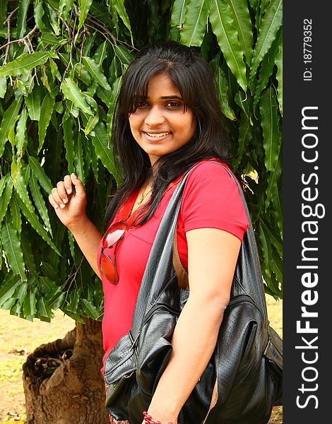 Woman in red dress with a black leather hand bag and a goggles clinging on her t-shirt. Woman in red dress with a black leather hand bag and a goggles clinging on her t-shirt.