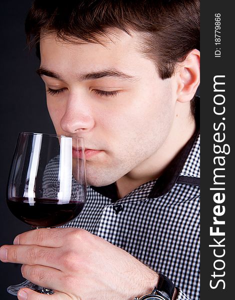 Young Man Smelling A Glass Of Red Wine