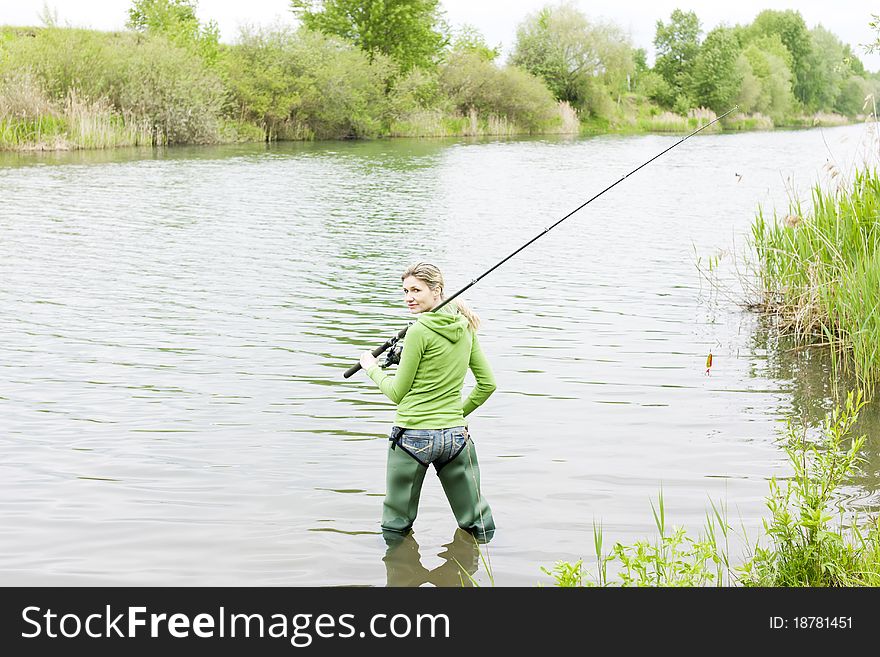 Standing woman fishing in pond. Standing woman fishing in pond