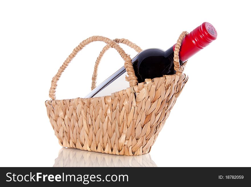 A bottle red wine on a gift wicker basket isolated over white