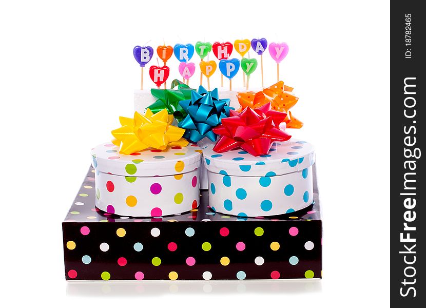 Cheerful dotted gift boxes with bows and birthday candles isolated over white