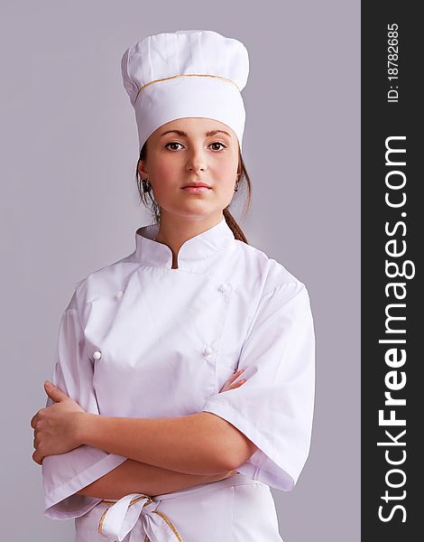 Young woman in white chef dress with hat. Young woman in white chef dress with hat
