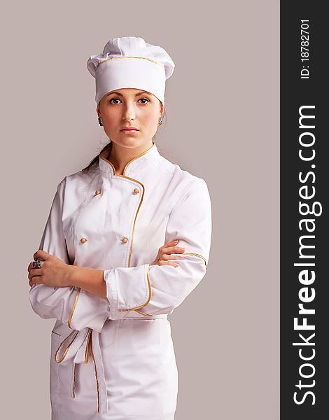 Young woman in white chef dress with hat. Young woman in white chef dress with hat