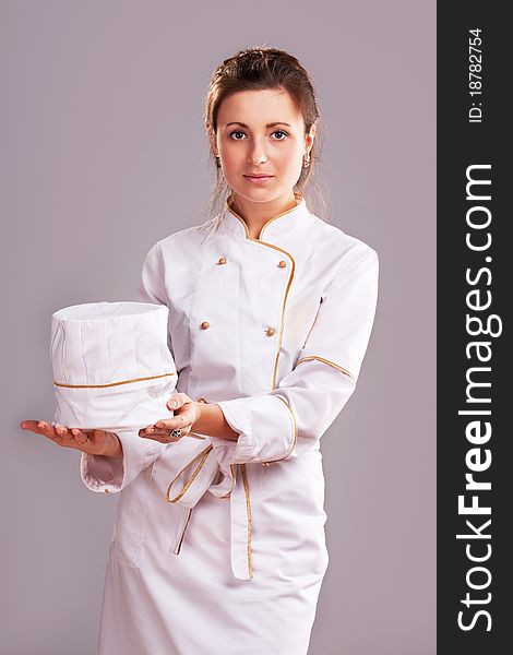 Young woman in white chef dress with hat. Young woman in white chef dress with hat