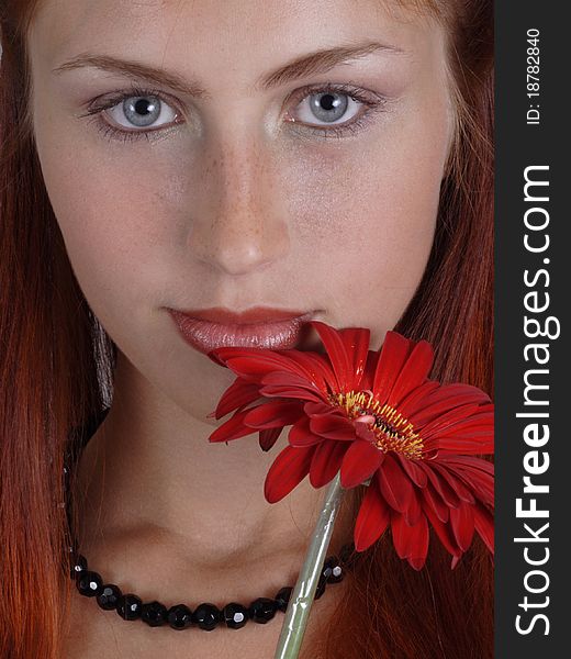 Portrait of the red-haired girl with a red flower. Portrait of the red-haired girl with a red flower