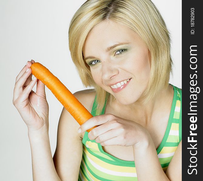 Portrait of young woman with a carrot