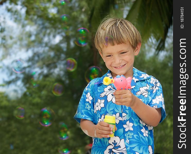 Boy playing with bubbles on natural background