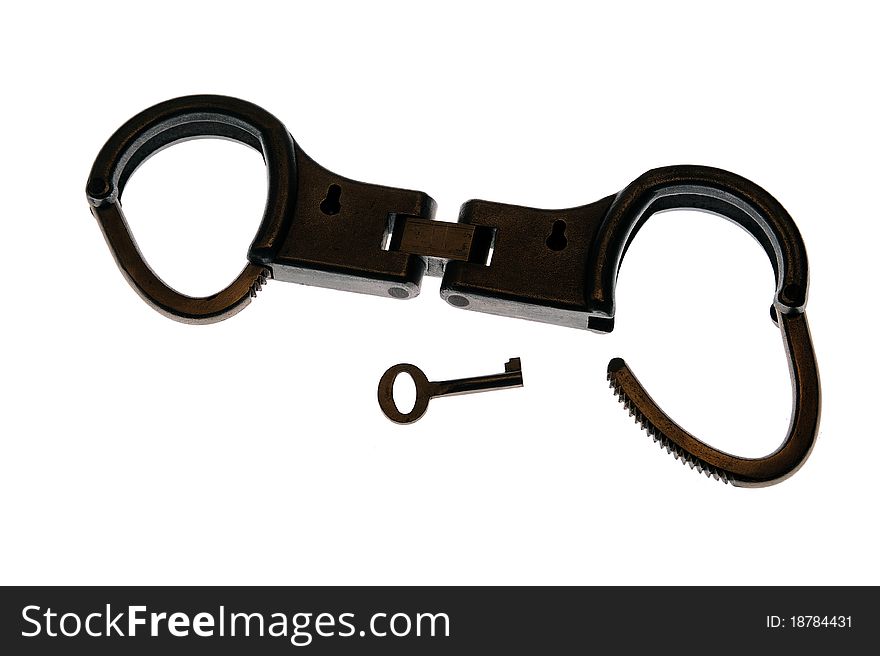 Handcuffs in semi silhouette against a white backdrop. One end open, one end secured, with key. Handcuffs in semi silhouette against a white backdrop. One end open, one end secured, with key.