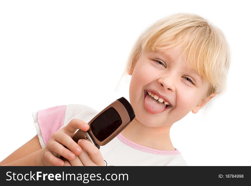 Little girl with a mobile phone shows his tongue, white background