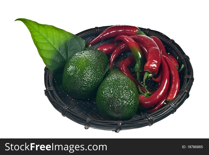 Avocado and red peppers in a basket isolated on white