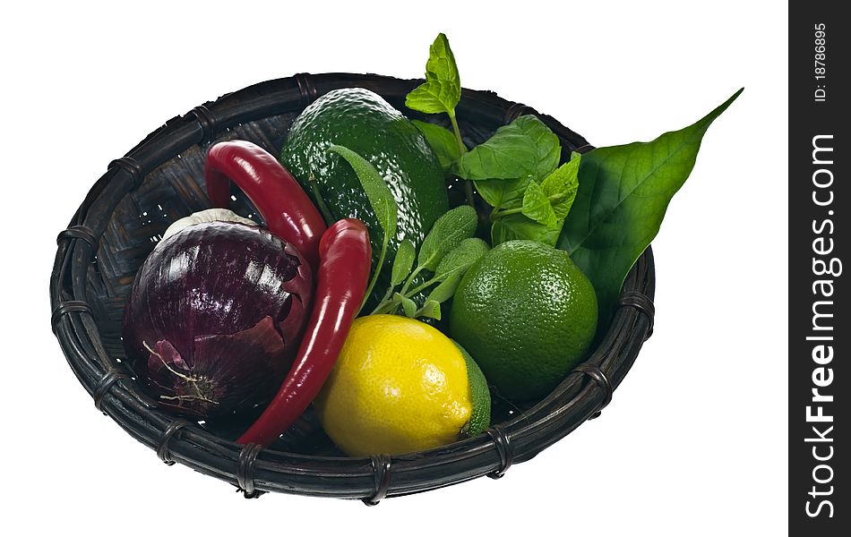 Basket with vegetables and herbs isolated on white