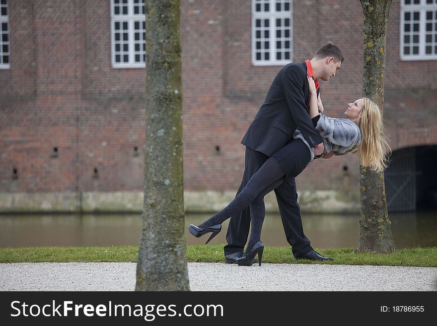 Love couple in park - man holding woman in his hands