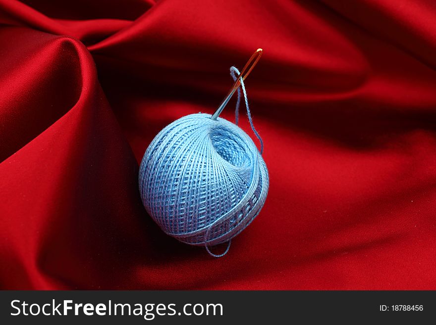 Thread on red silk isolated close up