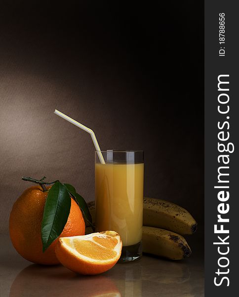 Orange and orange juice in a glass on a dark background