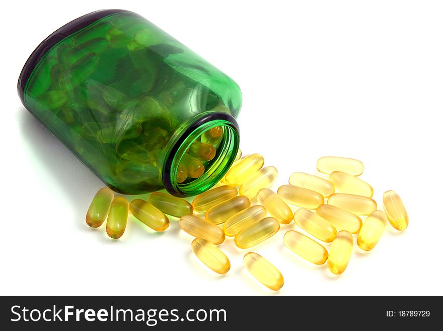 Green bottle and pills on white brackground