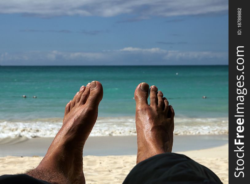 Feet of a man relaxing on the beach. Feet of a man relaxing on the beach