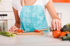 Woman Cutting Vegetables In A Kitchen Stock Photo