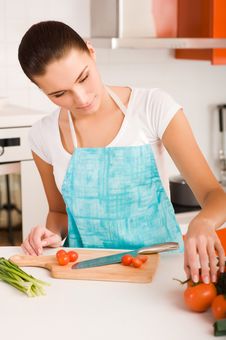 Woman Cutting Vegetables In A Kitchen Stock Images