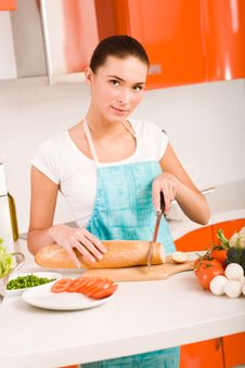Woman Cutting Bread On The Kitchen Royalty Free Stock Photography