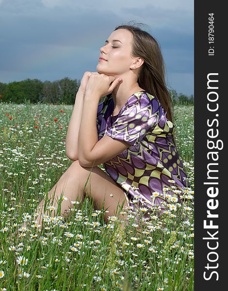 Young happy resting girl in daisy field