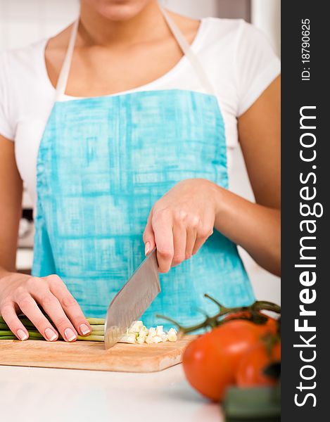 Woman cutting vegetables in modern kitchen