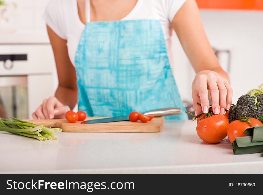 Woman Cutting Vegetables In A Kitchen